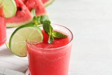 Photo of Tasty summer watermelon drink with lime and mint on table, closeup