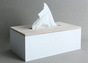 Photo of Holder with paper tissues on grey background