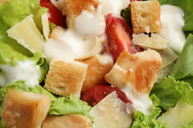 Photo of Tasty Caesar salad with chicken as background, closeup