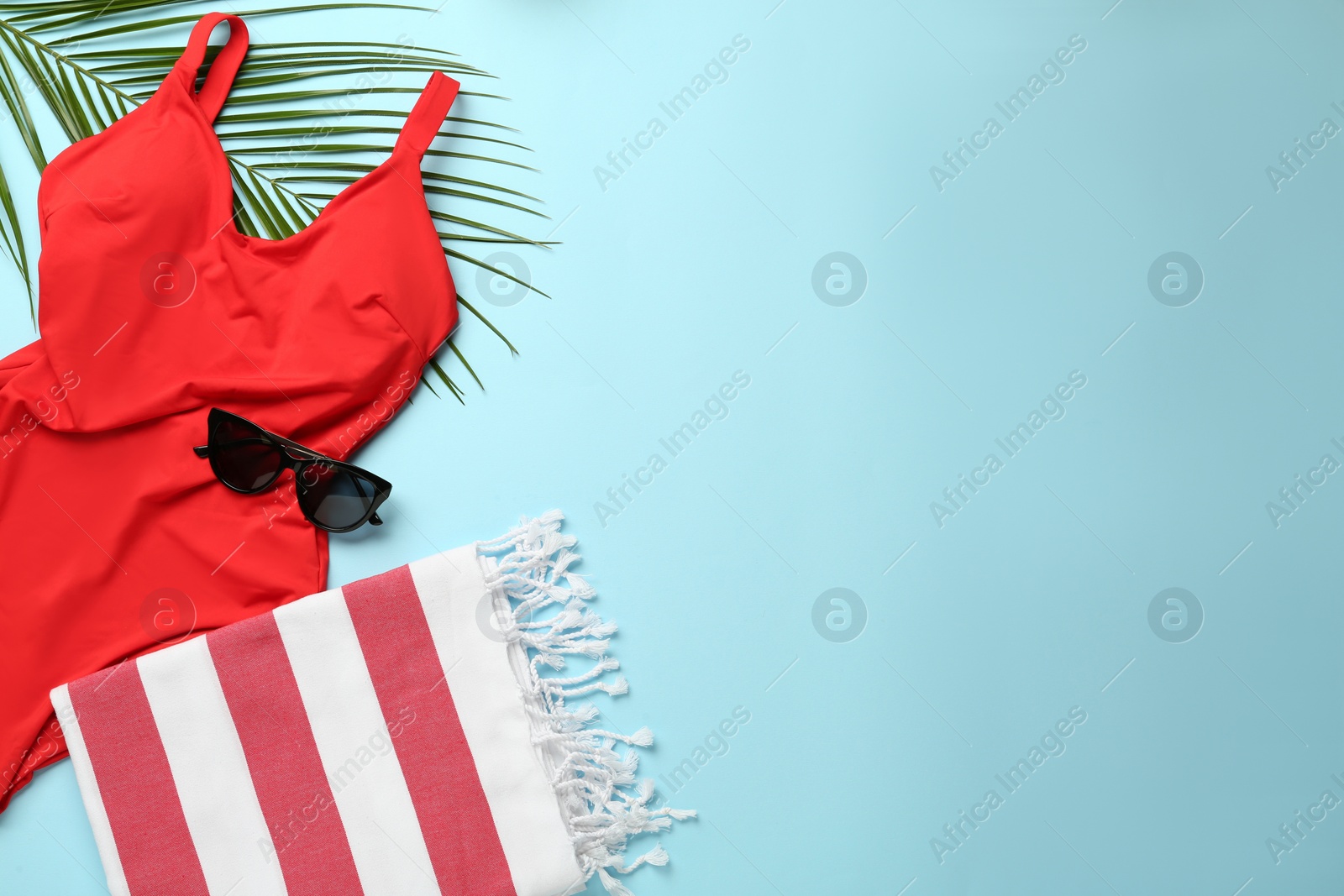 Photo of Flat lay composition with different beach objects on light blue background, space for text