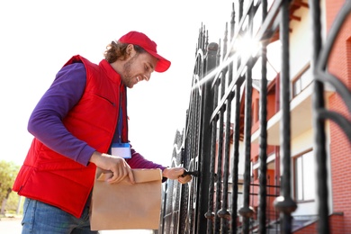 Male courier delivering food in city on sunny day