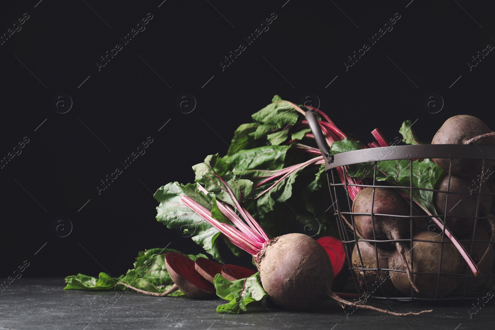 Photo of Whole ripe beets on black table. Organic vegetable