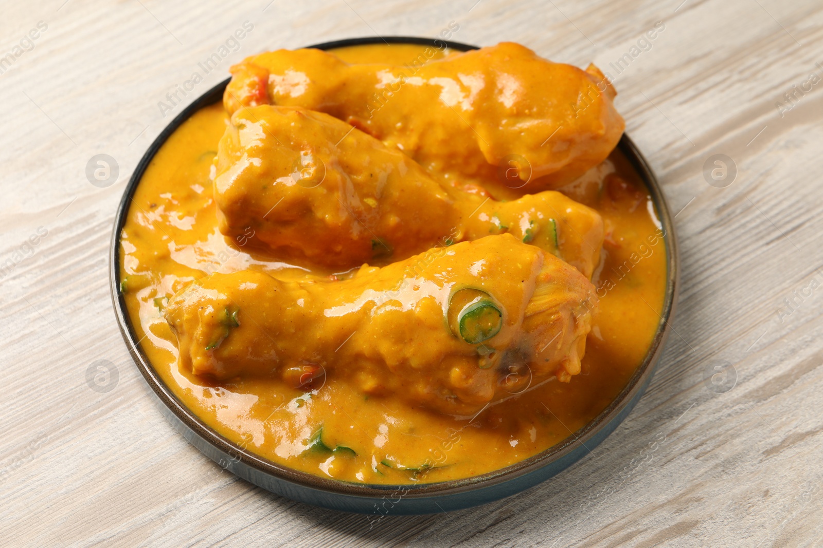 Photo of Tasty fresh chicken curry on wooden table