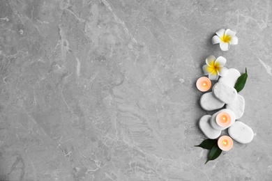 Photo of Flat lay composition with spa stones, flowers and candles on grey marble background. Space for text