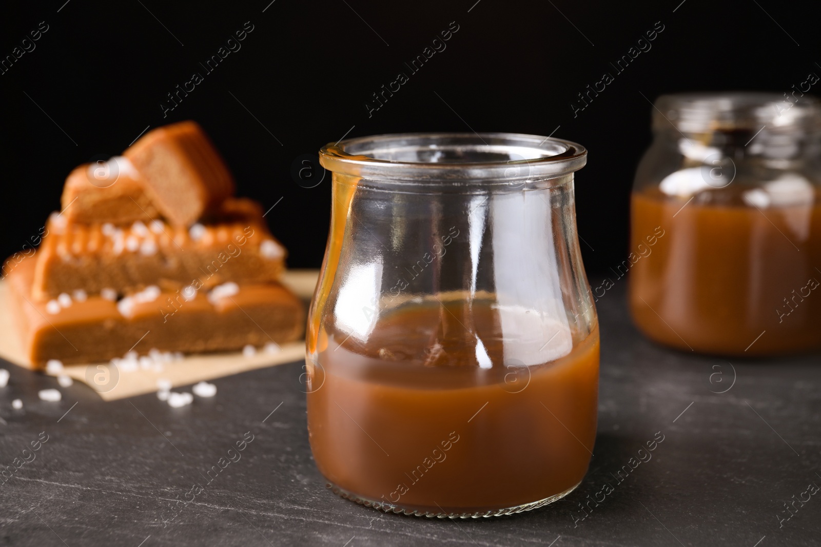 Photo of Salted caramel in jar on grey table