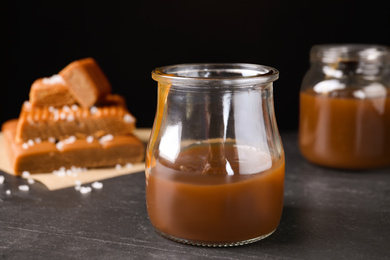 Salted caramel in jar on grey table