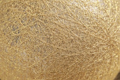 Texture of sphere made with golden threads, closeup