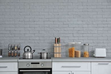 Photo of Modern kitchen interior with new furniture and different utensils