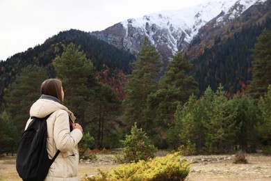 Photo of Woman with backpack in beautiful mountains, back view