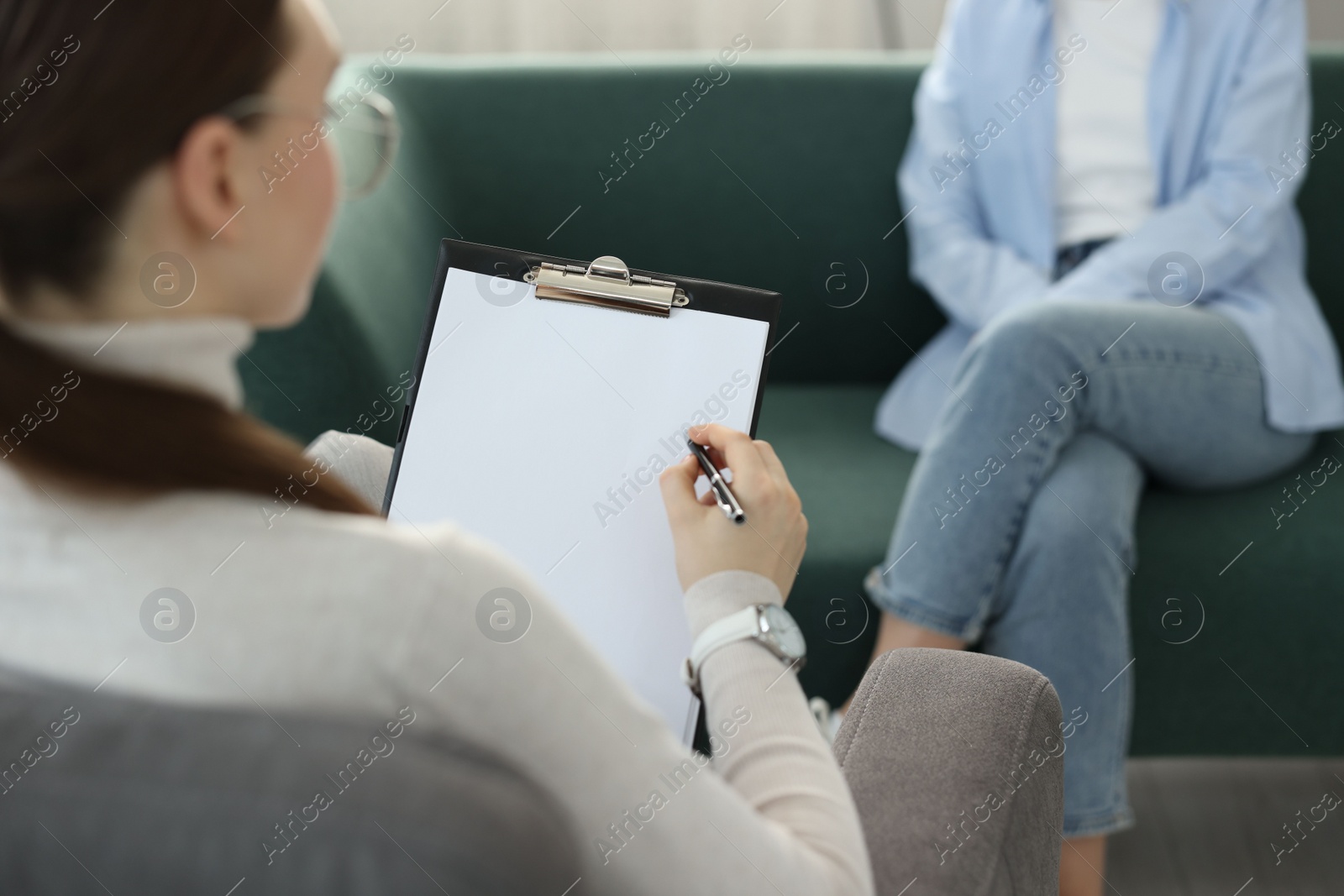 Photo of Professional psychotherapist working with patient in office, closeup