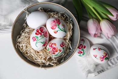Photo of Flat lay composition with painted Easter eggs on white table