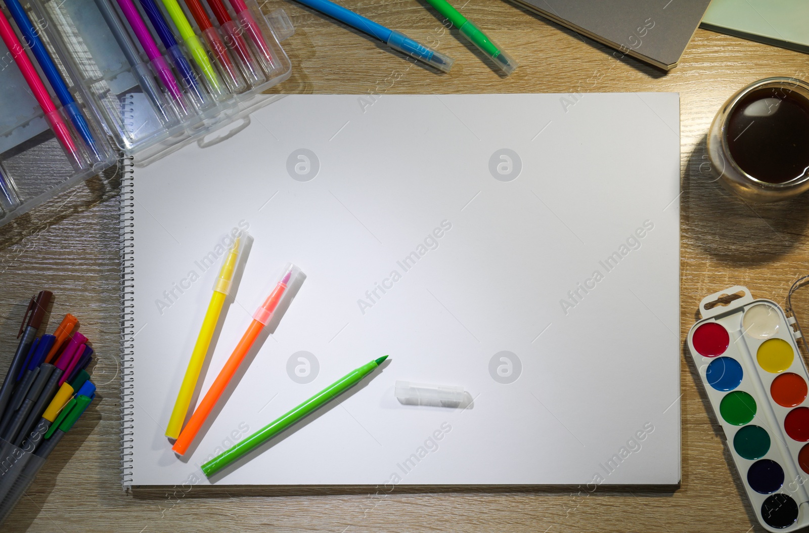 Photo of Flat lay composition with sketchbook and felt tip pens on wooden table