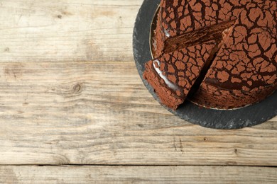 Photo of Delicious chocolate truffle cake on wooden table, top view. Space for text