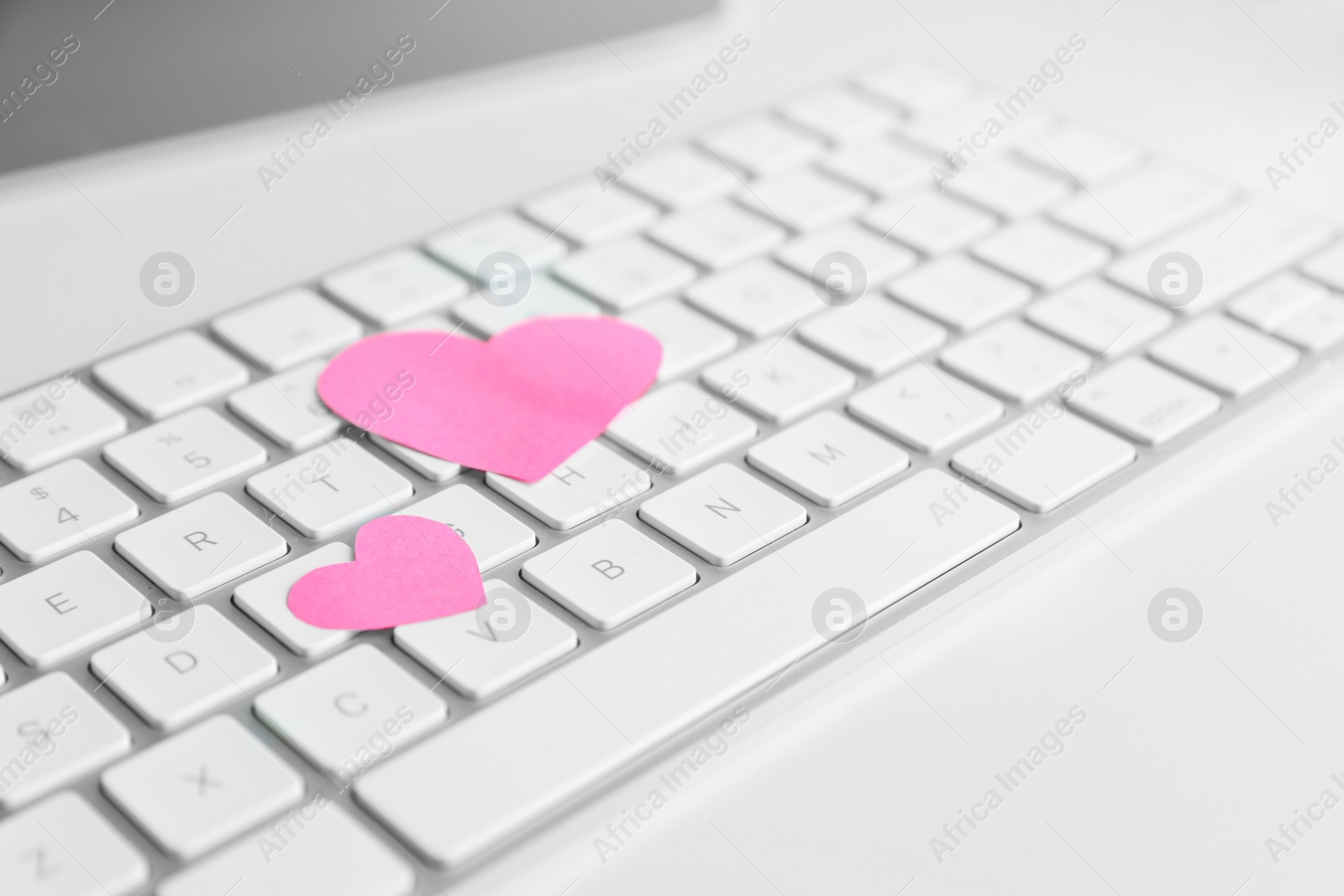 Photo of Keyboard with pink hearts on white table. Valentine's day celebration
