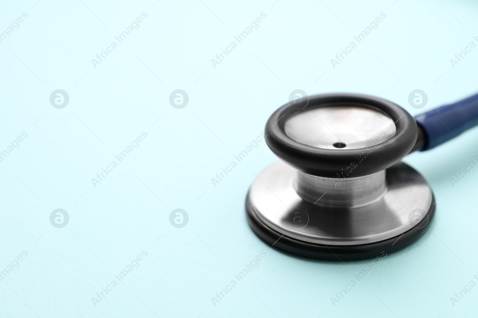 Photo of Stethoscope on light blue background, closeup. Space for text