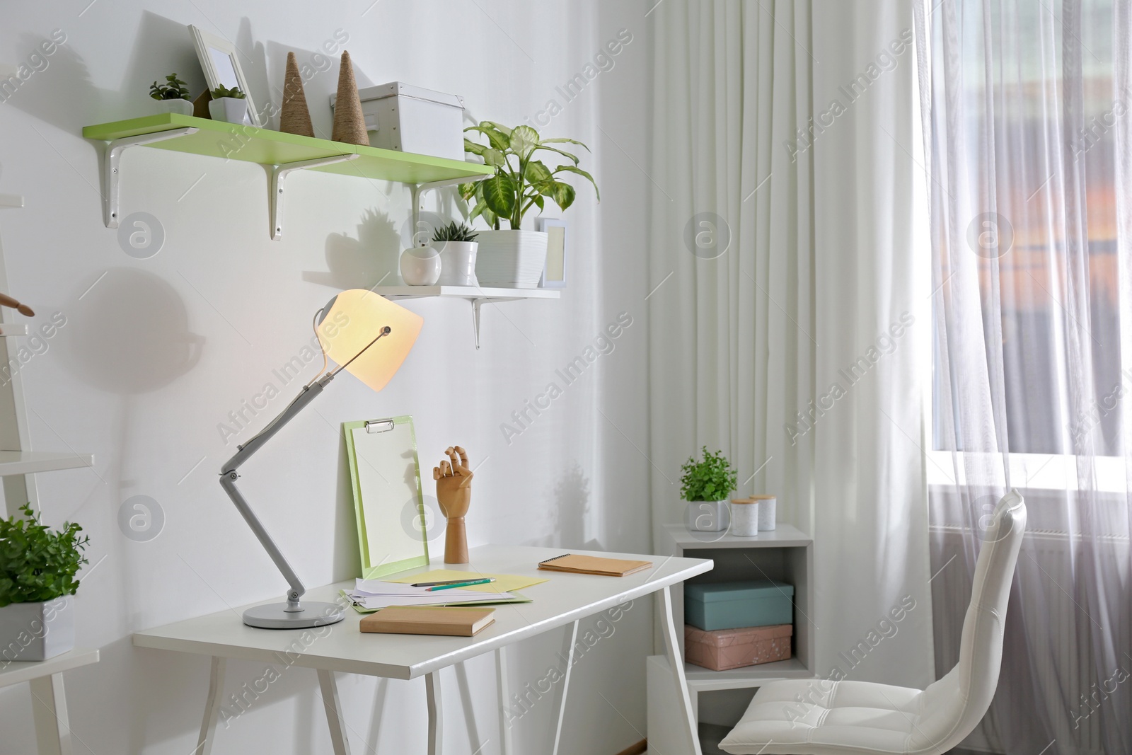 Photo of Stylish room interior with comfortable workplace near window. Design idea