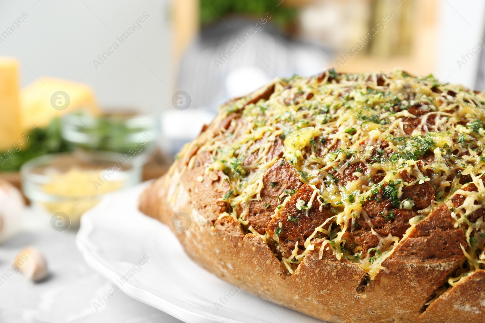 Photo of Tasty homemade garlic bread with cheese and herbs on grey table, closeup. Space for text