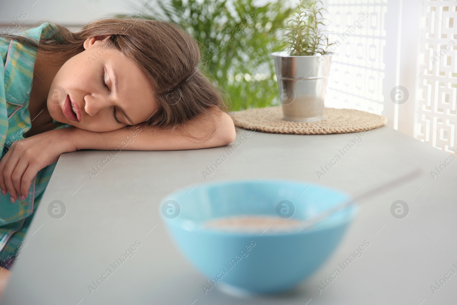 Photo of Young woman sleeping at table in morning