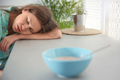 Young woman sleeping at table in morning