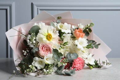 Photo of Bouquet of beautiful flowers on light grey table