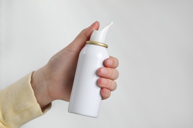 Woman with nasal spray on white background, closeup