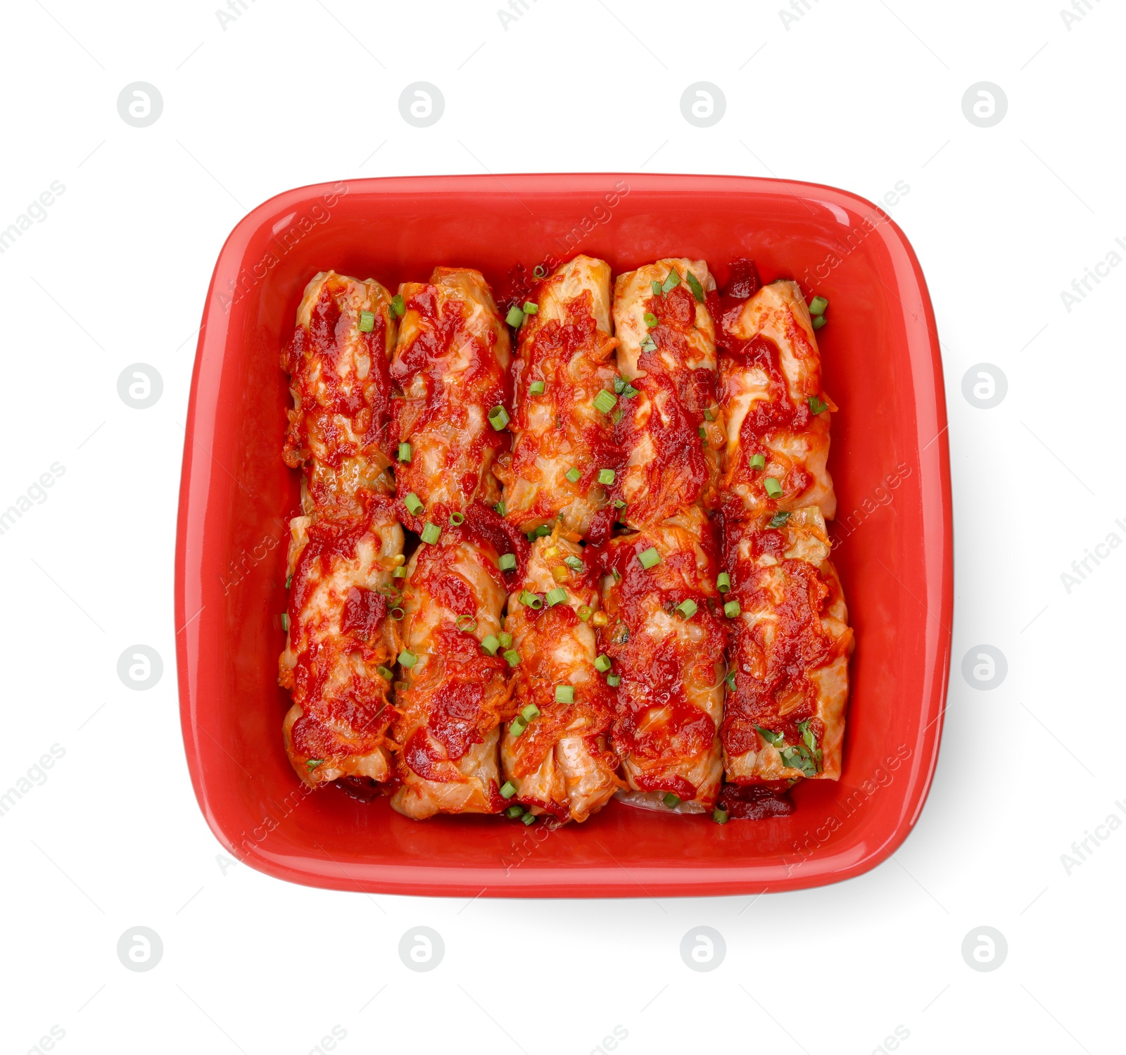 Photo of Baking dish of delicious stuffed cabbage rolls cooked with homemade tomato sauce isolated on white, top view