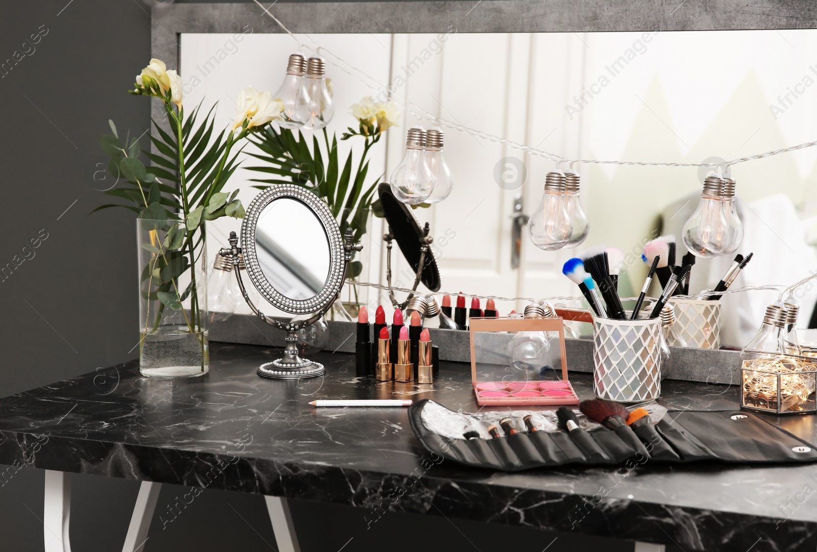 Photo of Decorative cosmetics and tools on dressing table in makeup room