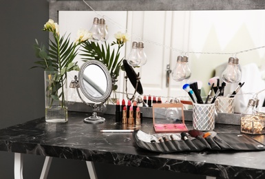 Decorative cosmetics and tools on dressing table in makeup room