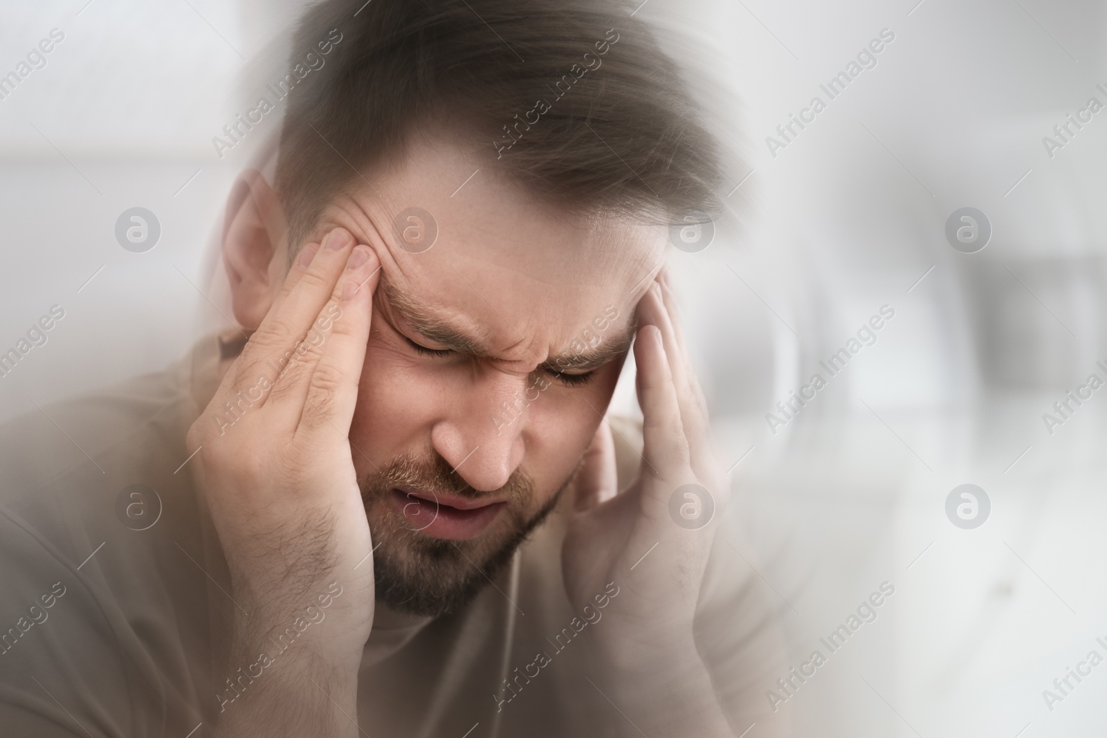 Image of Young man suffering from migraine at home, closeup
