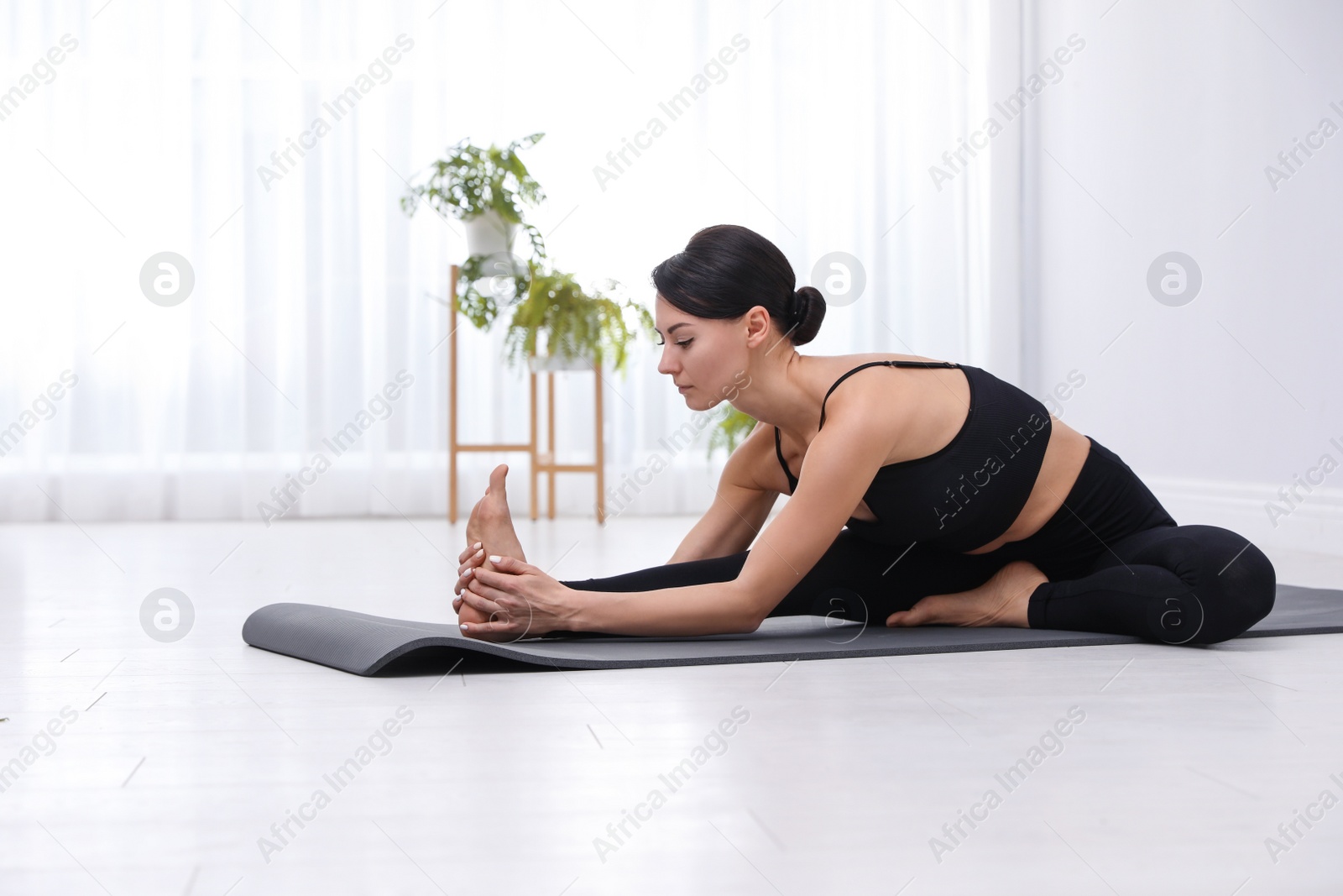 Photo of Professional young acrobat practicing yoga at home