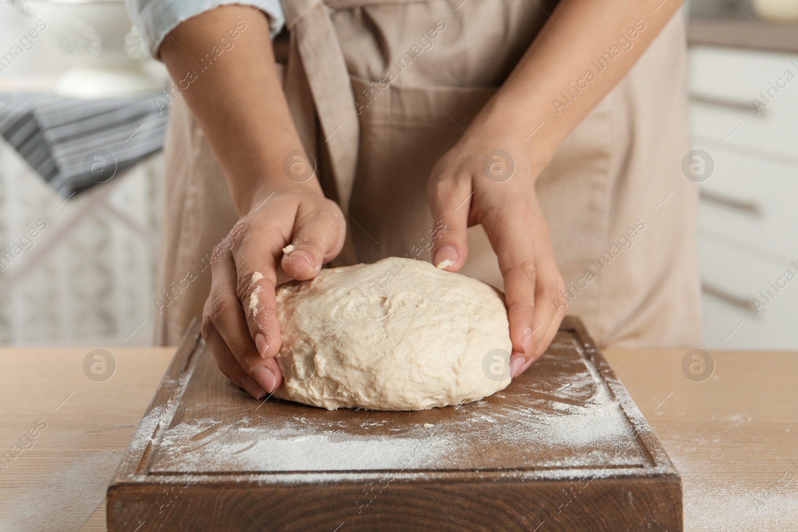 Photo of Female baker preparing bread dough at table, closeup