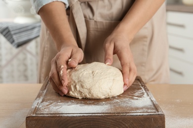 Female baker preparing bread dough at table, closeup