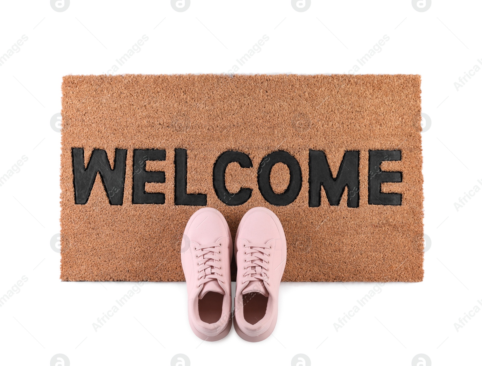 Photo of Stylish door mat with word Welcome and shoes on white background, top view