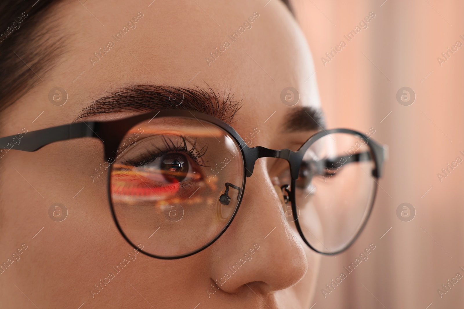 Photo of Woman wearing glasses on blurred background, closeup