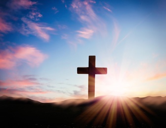 Image of Christian cross on hill outdoors at sunrise. Resurrection of Jesus