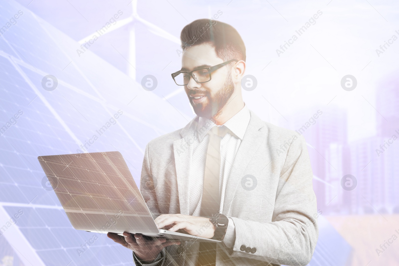 Image of Multiple exposure of businessman with laptop, wind turbines and solar panels installed outdoors. Alternative energy source