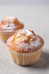 Photo of Delicious sweet muffins on light grey textured table, closeup. Space for text