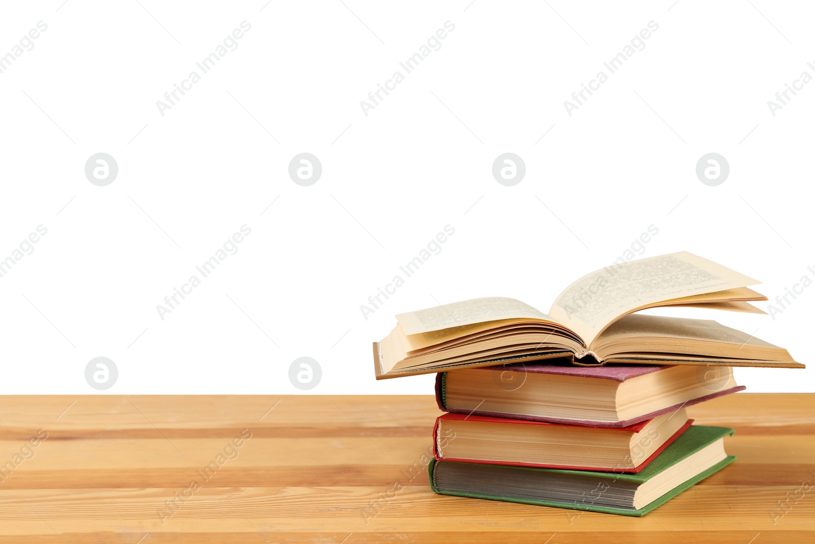Photo of Stack of books on wooden table against white background. Library material