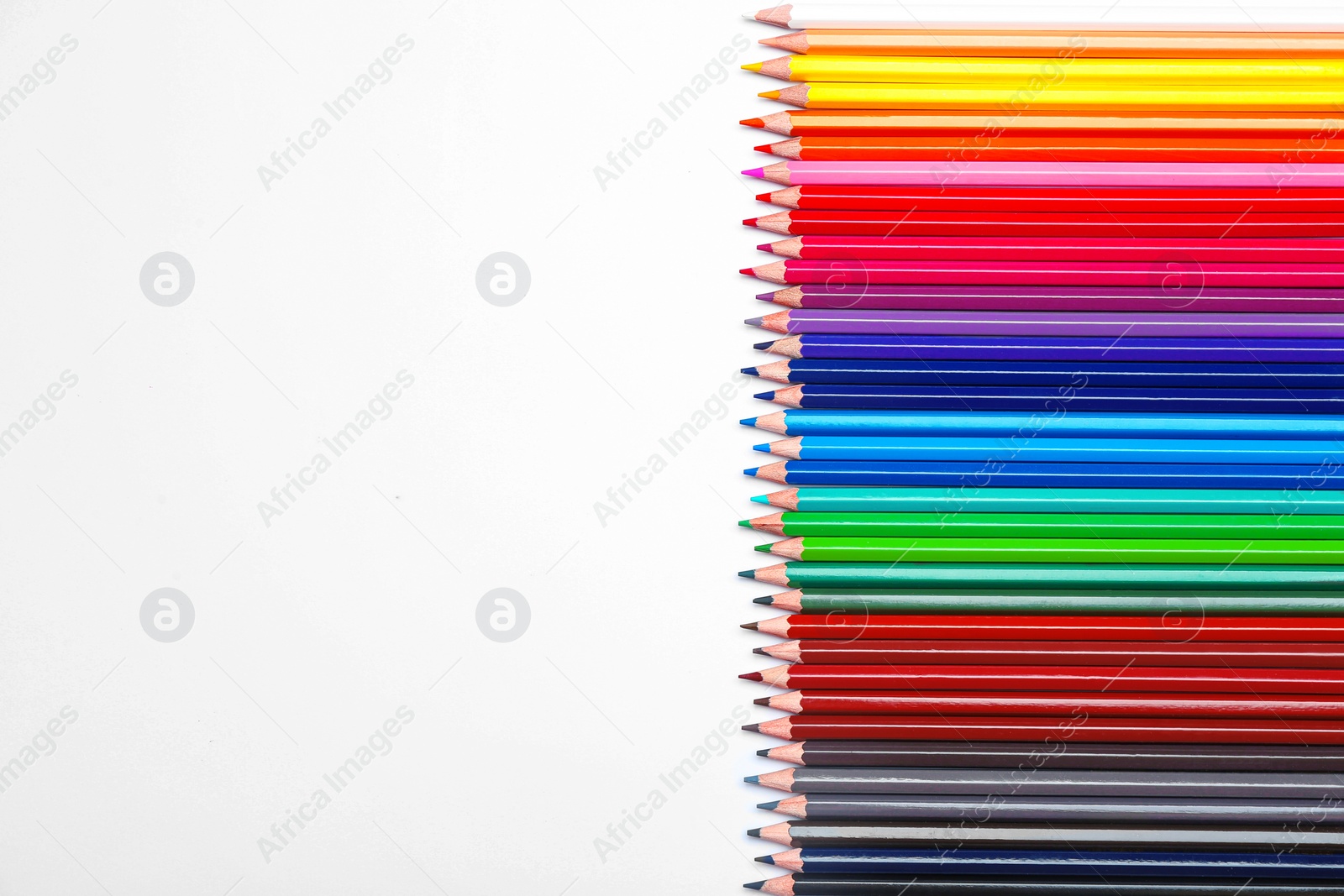 Photo of Color pencils on white background, top view. Space for text