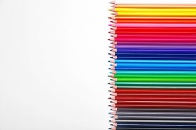 Photo of Color pencils on white background, top view. Space for text