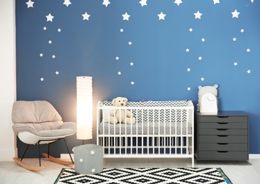 Photo of Baby room interior with comfortable crib and rocking chair