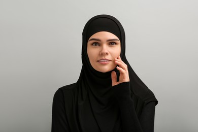 Photo of Portrait of Muslim woman in hijab on light gray background