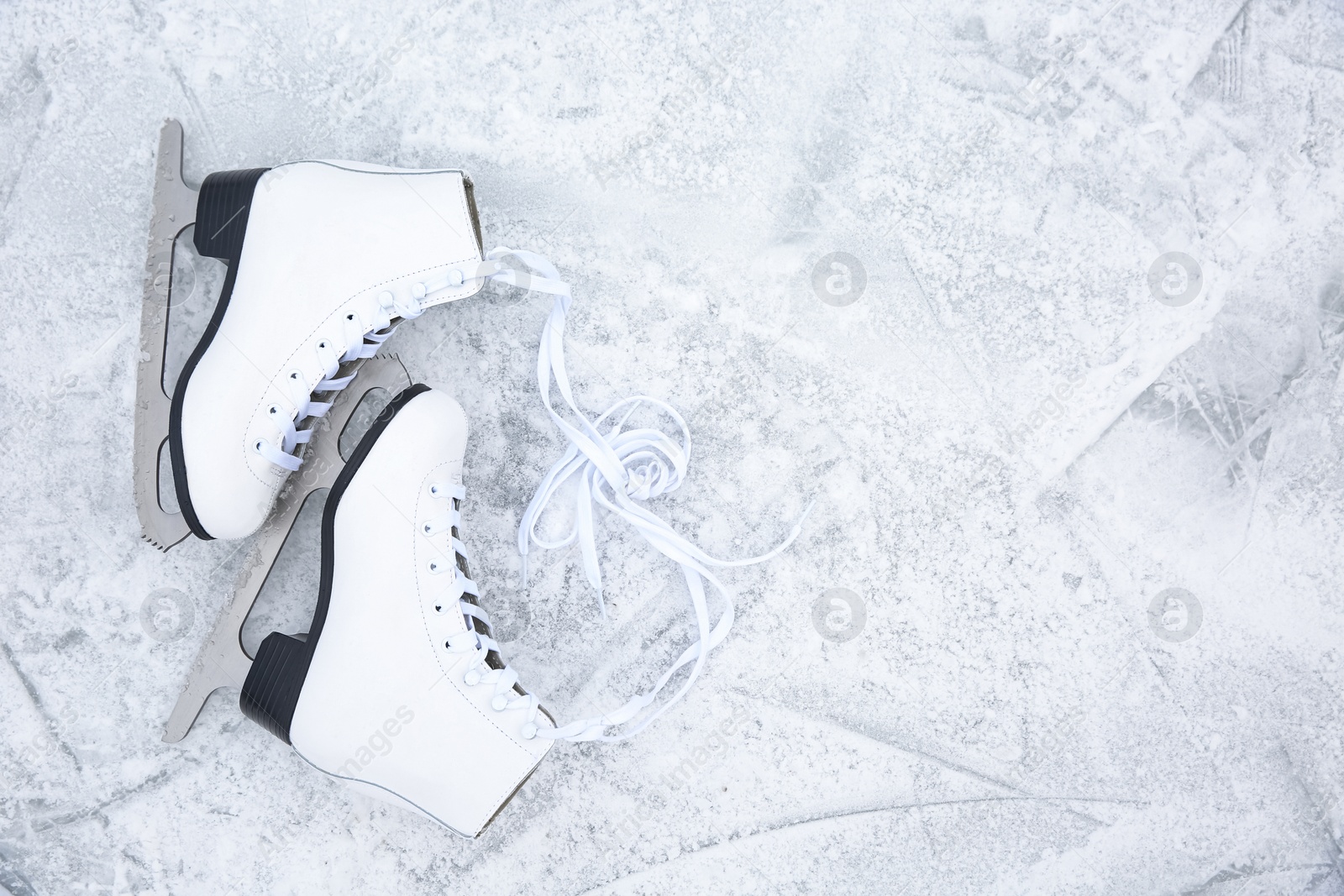 Photo of Pair of figure skates on ice, flat lay with space for text. Winter outdoors activities