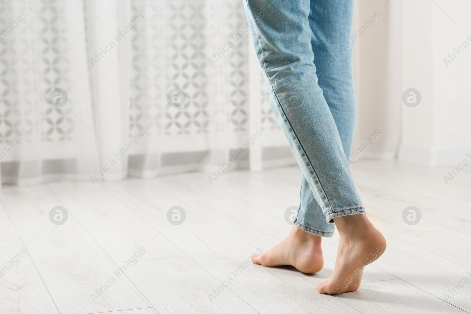 Photo of Woman stepping barefoot in room at home, closeup with space for text. Floor heating