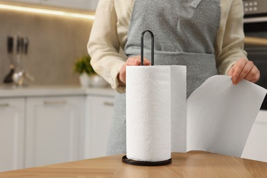 Photo of Woman using paper towels in kitchen, closeup. Space for text