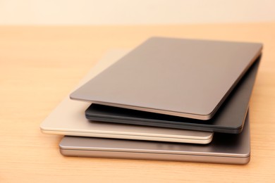 Photo of Different modern laptops on wooden table, closeup