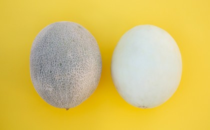 Photo of Different tasty ripe melons on yellow background, flat lay