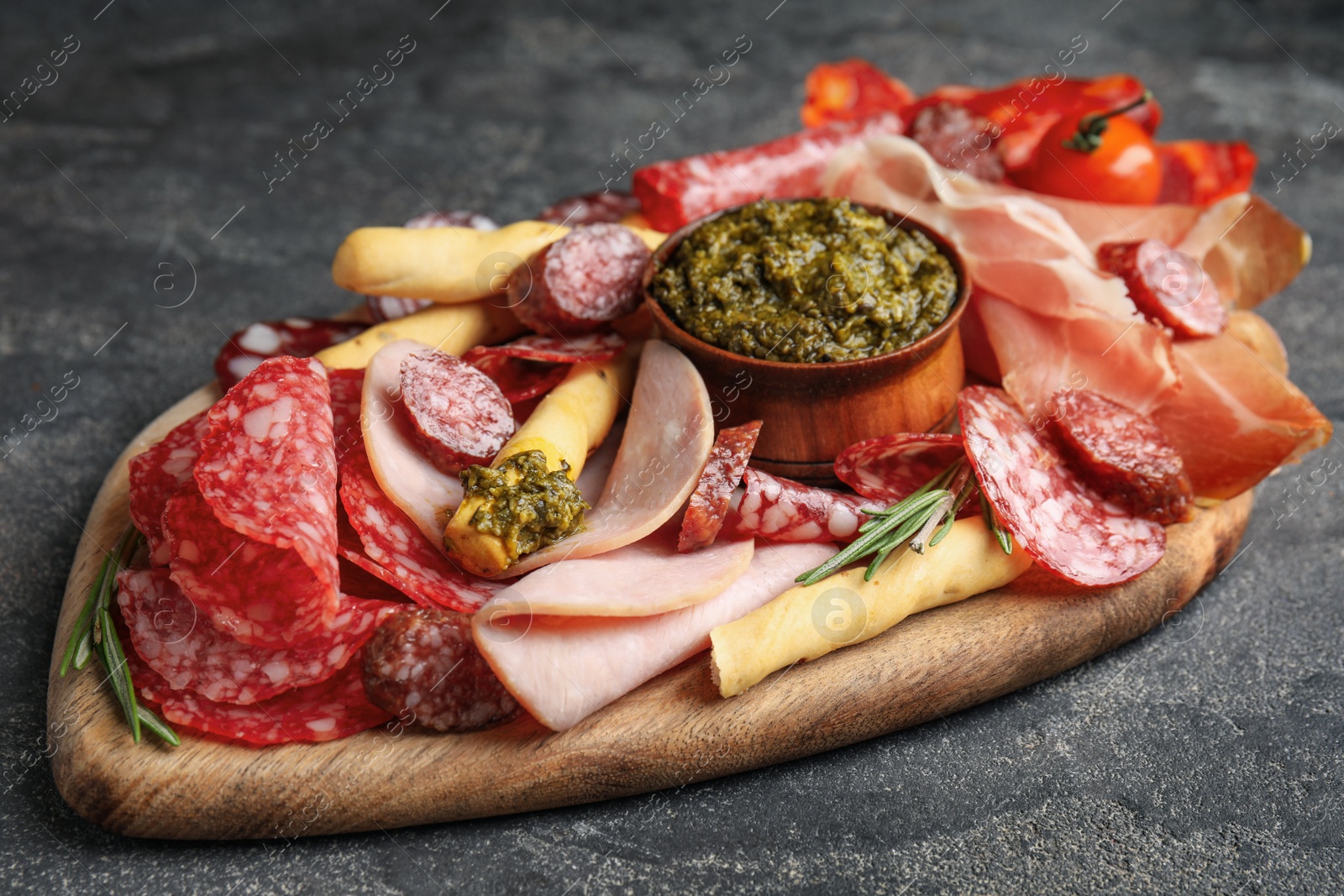 Photo of Tasty ham and other delicacies served on grey table, closeup