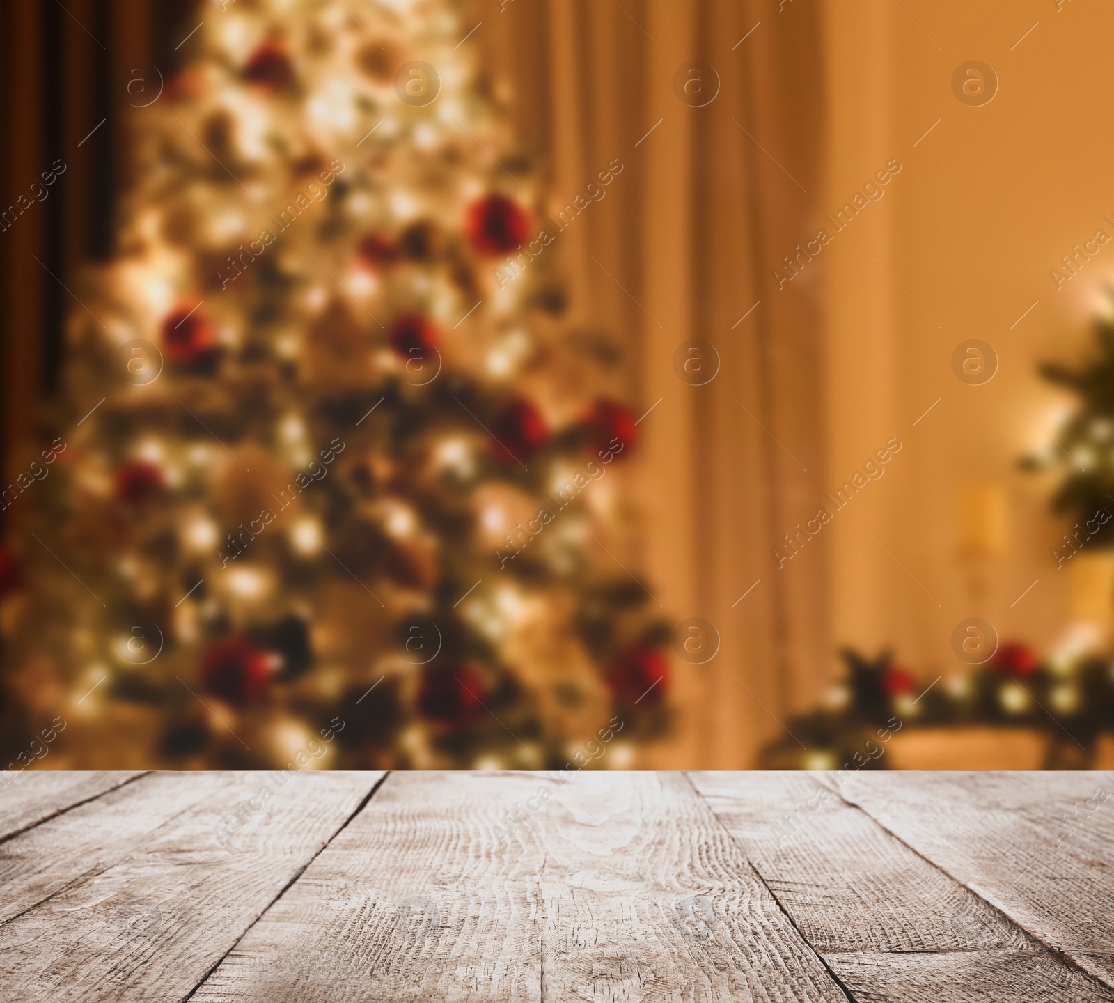 Image of Empty wooden surface and blurred view of Christmas tree in room, space for text. Interior design