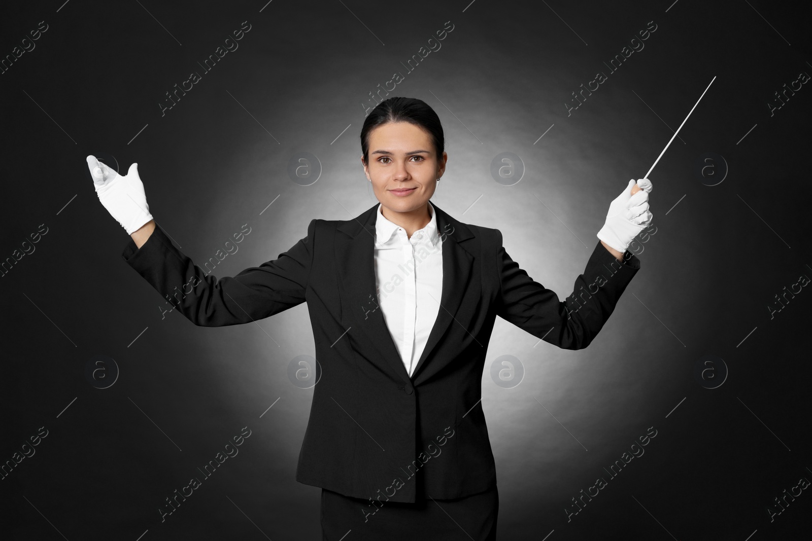 Photo of Professional conductor with baton on black background